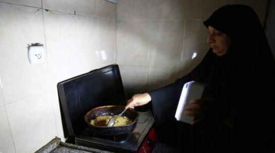 امرأة غزية تطهور الطعام على ضوء الكشاف (ارشيف)
