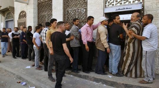 موظفون امام احد البنوك في غزة