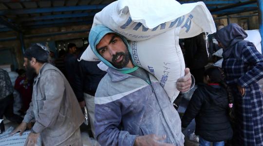 لاجئون يتلقون مساعدات من الأونروا