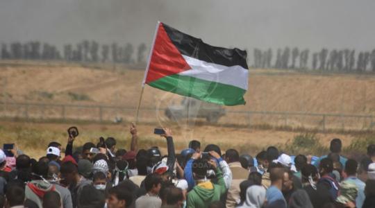 فتاتان ترفعان العلم الفلسطيني على السياج الحدودي شرق رفح