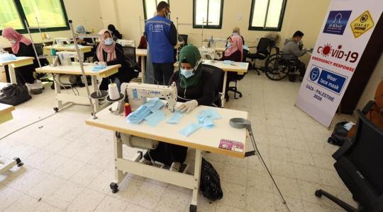 عمال من ذوي الإعاقة داخل مشغل بغزة لحياكة الكمامات الطبية