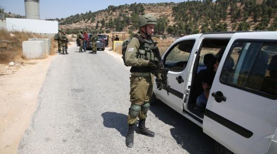 جندي من جيش الاحتلال الاسرائيلي يفتش مركبات المواطنين