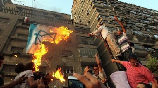متظاهرون مصريون يحرقون العلم الاسرائيلي ابان اقتحام السفارة الإسرائيلي في القاهرة عام 2011