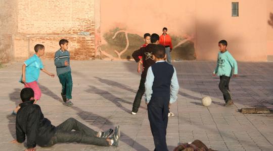 أطفال يلعبون الكرة في الشارع