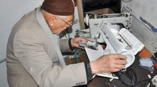 مسن يعمل في مهنة الخياطة