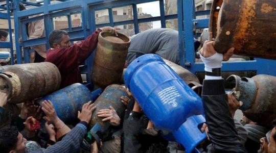 مواطنون يحملون أسطوانات الغاز لتعبئتها من إحدى محطات الغاز بقطاع غزة