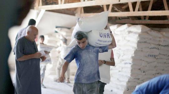 لاجئون فلسطينيون يتلقون مساعدات من الأونروا