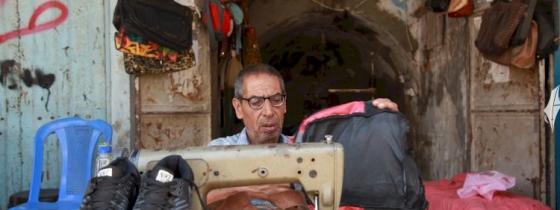 الخياط خليل حمدان يُعيد خياطة الأحذية والحقائب البالية للطلاب قبل بداية العام الدراسي الجديد
