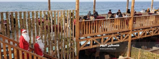 فلسطينيان يرتديان "بابا نويل" اثناء عملهما في احدى المقاهي بغزة