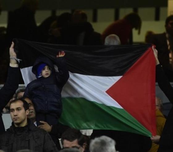 الطفل أحمد الدوابشة رافعاً العلم خلال حضوره مباراة ريال مدريد وإشبيلية