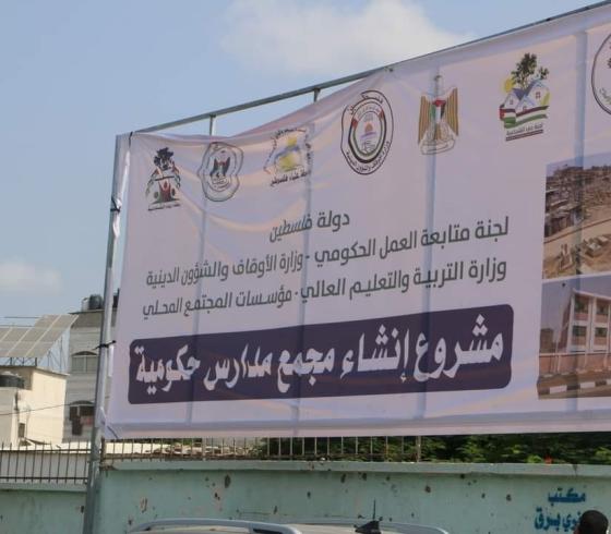رفع لافتة أمام مقبرة (التوانسي) في الشجاعية لمشروع إنشاء مجممع مدارس حكومية