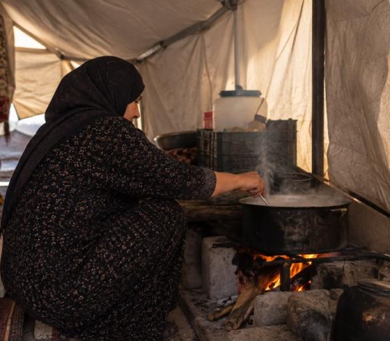 امرأة تطهو داخل الخيمة
