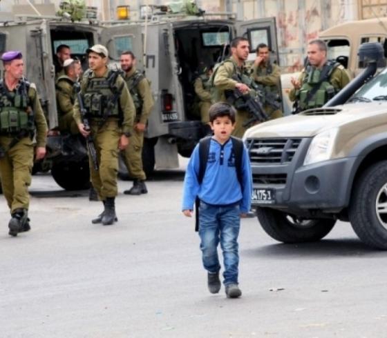 طفل فلسطيني يسير أمام حاجز عسكري