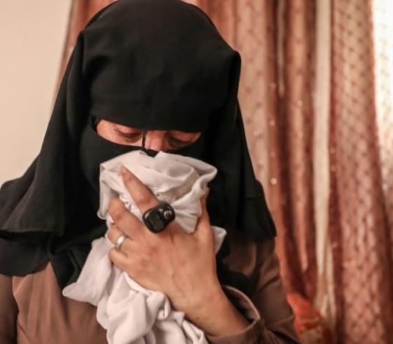 والدة الشهيد وصال الشيخ خليل وهي تشتم ملابس ابنتها