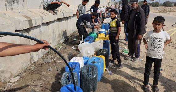 مواطنون يصطفون في طابور من أجل تعبئة جالوناتهم بمياه الشرب في غزة (ارشيف)