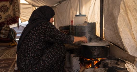 امرأة تطهو داخل الخيمة