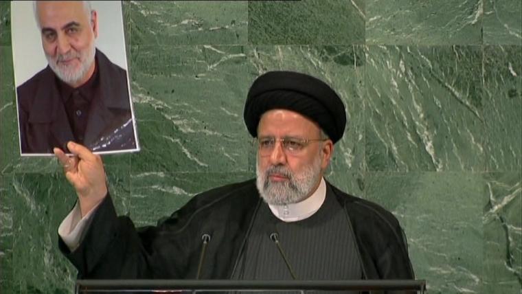 الرئيس الإيراني يرفع صورة الشهيد قاسم سليماني