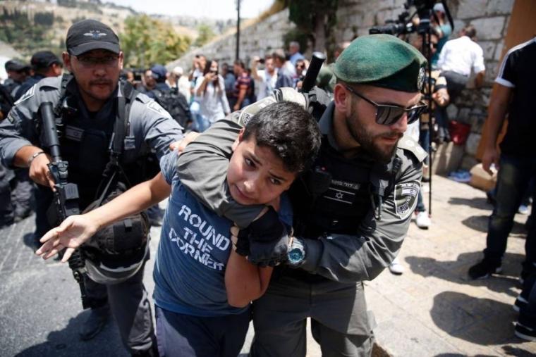 جندي إسرائيلي يعتدي على طفل فلسطيني.jpg