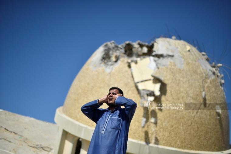 مؤذن يقيم الصلاة من فوق ركام مسجد دمره الاحتلال خلال العدوان على غزة