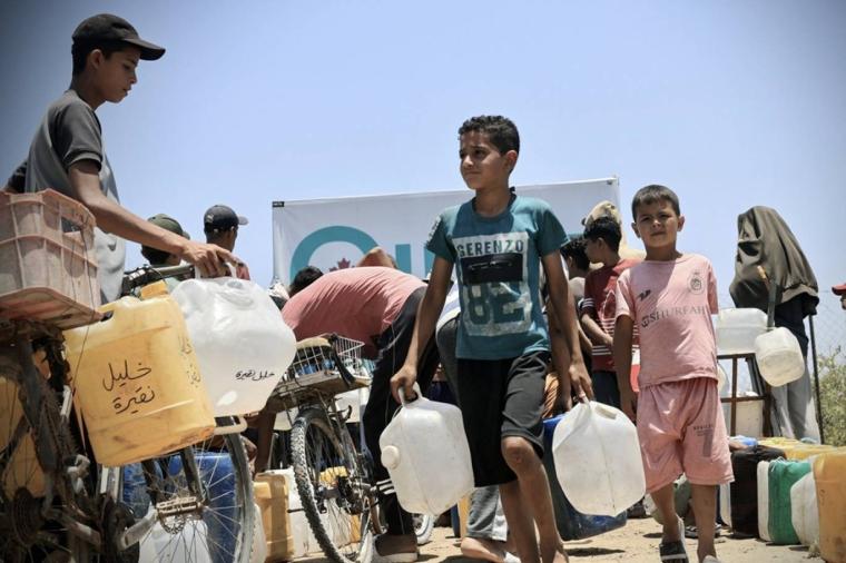 أطفال بغزة يصطفون طابور لتعبئة جالوناتهم بمياه الشرب