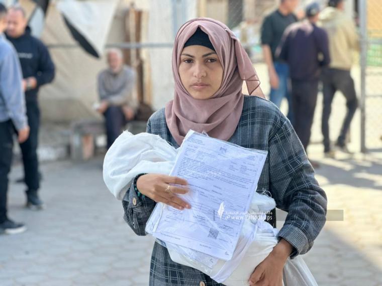 مواطنة تحمل جثمان طفلها (1).jpeg