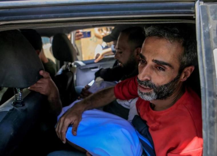يوسف سليمان يحمل طفله الشهيد جاد