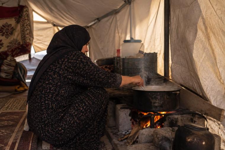 امرأة تطهو داخل الخيمة