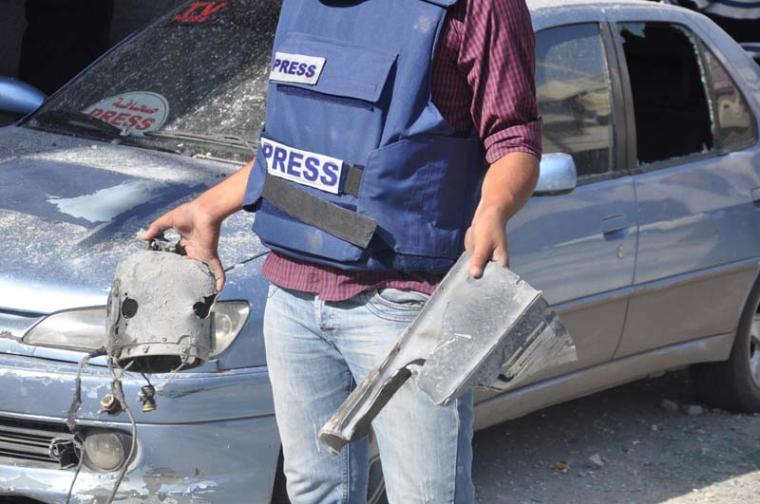 صحفي يحمل صاروخاً اسرائيليا استهدف مؤسسات صحفية