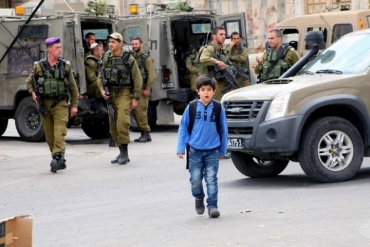 طفل فلسطيني يسير أمام حاجز عسكري