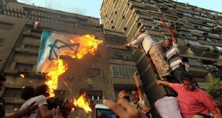 متظاهرون مصريون يحرقون العلم الاسرائيلي ابان اقتحام السفارة الإسرائيلي في القاهرة عام 2011
