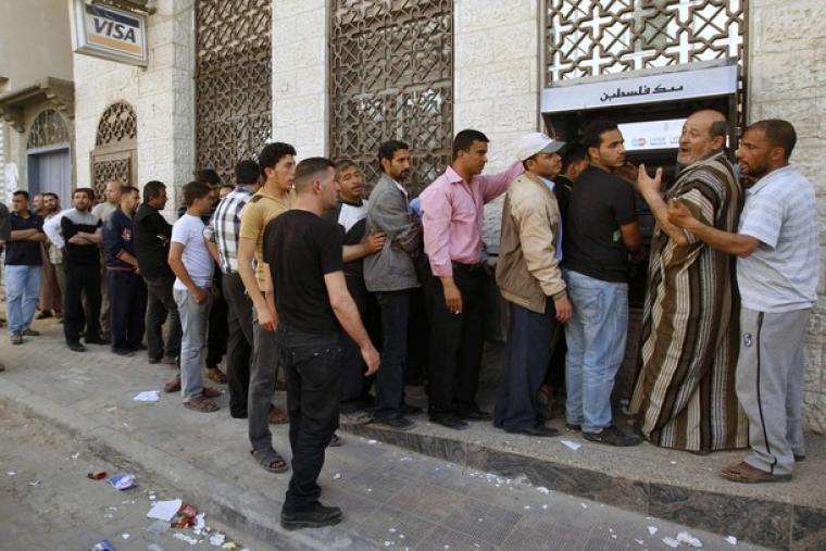 موظفون امام احد البنوك في غزة