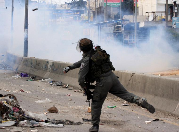 جندي "إسرائيلي" يلقي قنبلة غاز