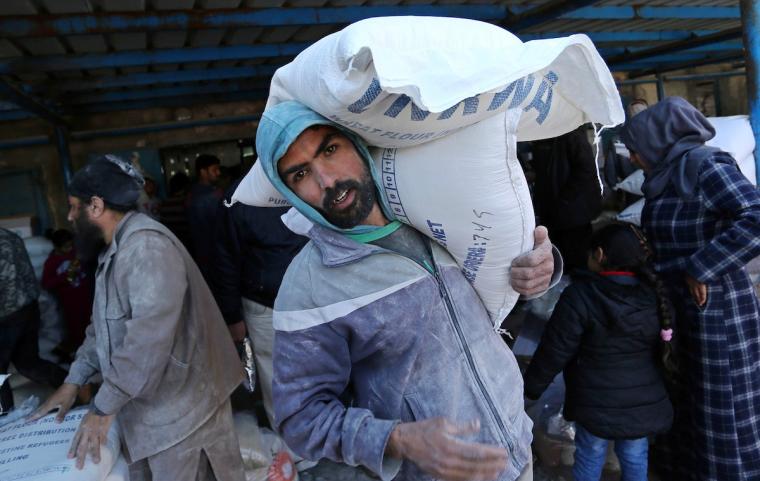 لاجئون يتلقون مساعدات من الأونروا