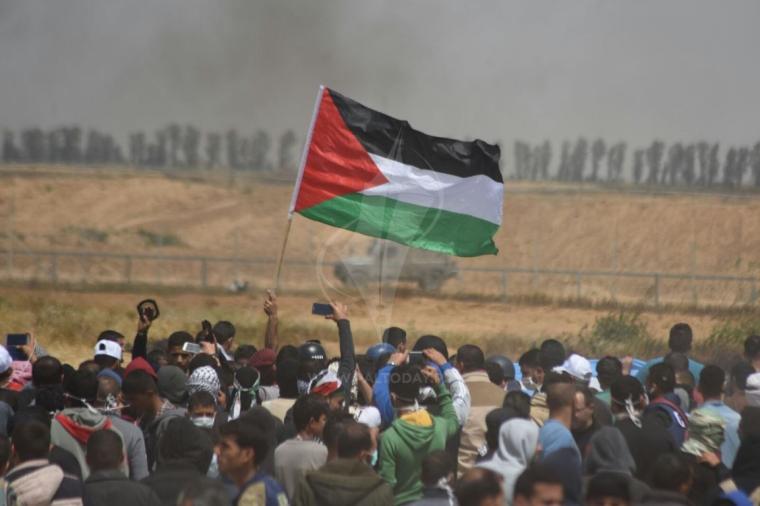 فتاتان ترفعان العلم الفلسطيني على السياج الحدودي شرق رفح