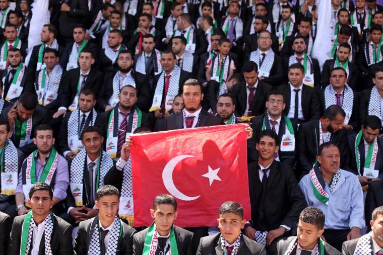 شاب يرفع علم تركيا خلال حفل زفاف جماعي مولته