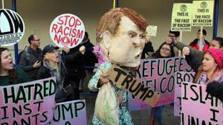 متظاهرون يرفعون لافتات ضد ترامب