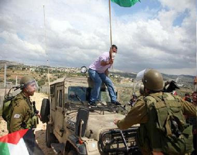 مواطن يرفع علم فلسطين فوق جيب صهيوني