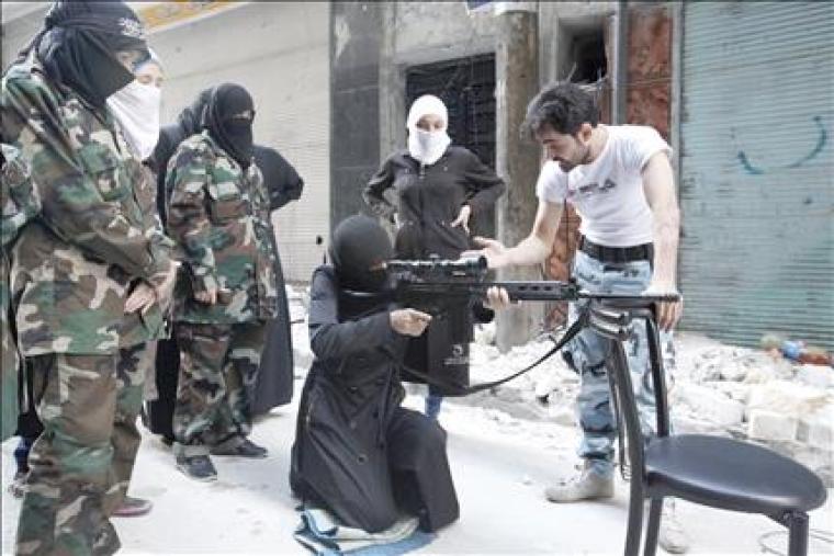 مسلحات سوريات من مجموعة «أمنا عائشة» يتدربن على استعمال القناصة في حلب أمس (رويترز)