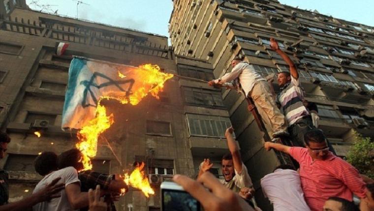 متظاهرون مصريون يحرقون العلم الاسرائيلي ابان اقتحام السفارة الإسرائيلي في القاهرة عام 2011