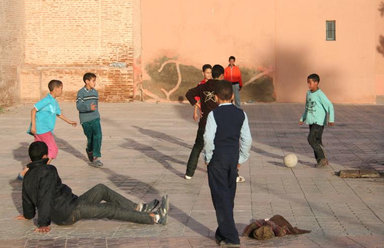 أطفال يلعبون الكرة في الشارع