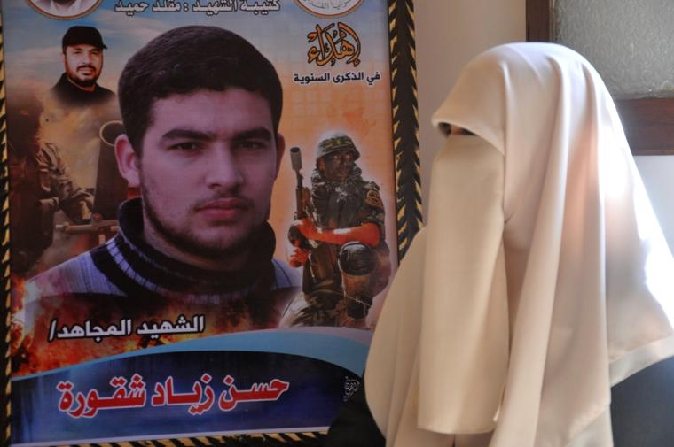 والدة الشهيد حسن شقورة بجوار صورة نجلها