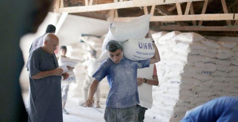 لاجئون فلسطينيون يتلقون مساعدات من الأونروا