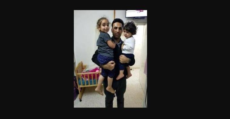 الاسير نجيب مفارجة يحتضن طفليه قبل اعتقاله.